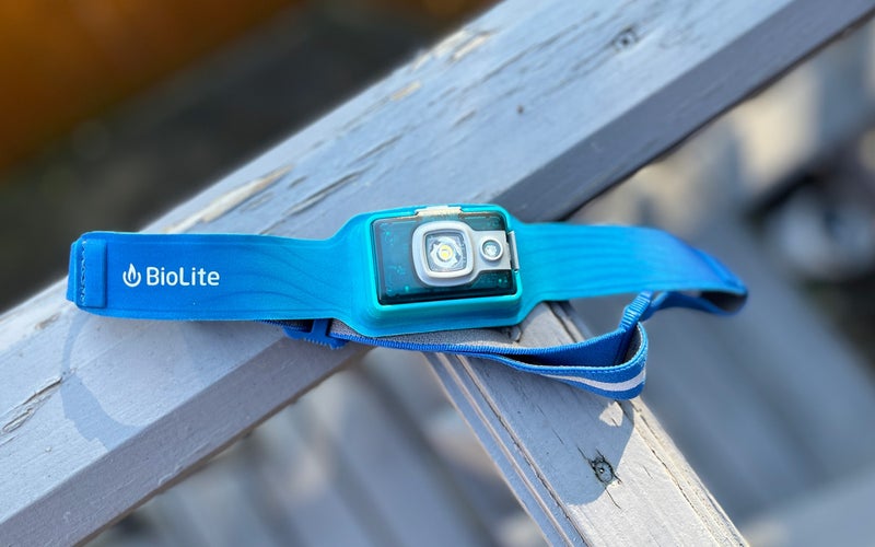 A blue BioLite HeadLamp 325 rests on a white deck railing.