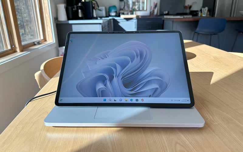 Blue and silver Microsoft Surface Laptop Studio 2 on a birch table