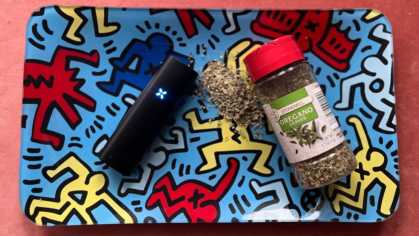 A Pax Plus cannabis vaporizer on a rolling tray with some oregano seasoning